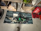 une boîte à outils posée par terre à côté d'une paire de chaussures