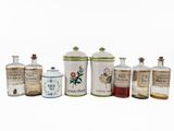 a group of old fashioned bottles and jars on a white surface
