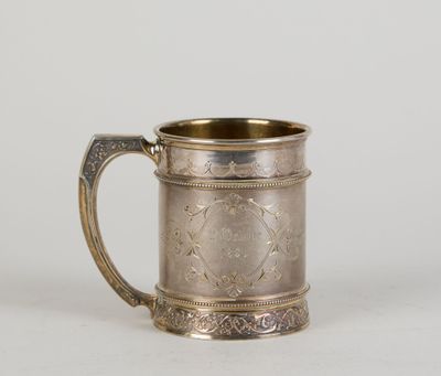 une tasse ancienne en métal argenté avec une anse, sur fond blanc