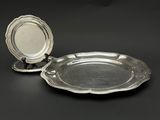 paire de plats argentés sur des socles, sur fond noir