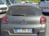 grey car parked in a parking lot with other cars in the background