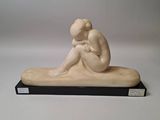 statue of a woman sitting on a bench with her head in her hands