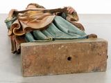a figurine of a woman laying on a bench