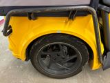 a yellow golf cart parked on the side of the road