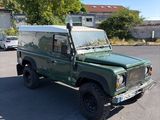 a green land rover parked in a parking lot