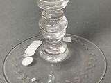 a glass candle holder with a candle on top of it