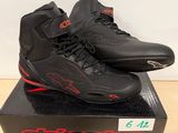 une paire de chaussures noires et rouges posée sur une boîte