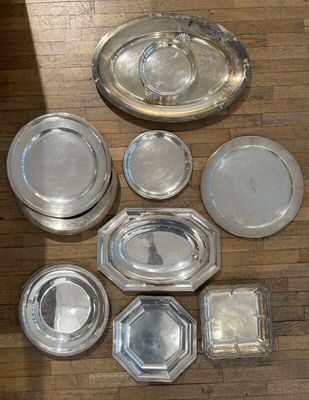 a lot of silver plates on the floor next to each other