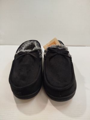 une paire de pantoufles noires doublées de fourrure, posées sur un fond blanc