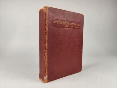un vieux livre à la couverture rouge posé sur une table