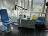 a dentist ' s chair in the corner of the room