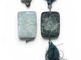 trois pièces de jade et des pendentifs en jade ornés de pompons, sur fond blanc