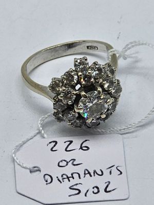 an image of a silver ring with a cluster of diamonds on it