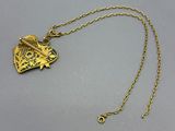 a close up of a gold necklace with a bird on it