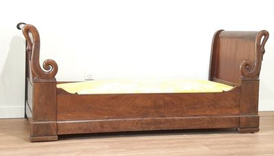un lit en bois recouvert d'une couverture jaune