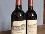 two bottles of wine sitting on top of a wooden table