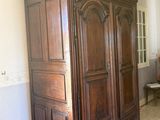 a large wooden armoire in the corner of a room