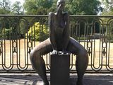une statue représentant un homme assis sur un banc