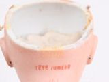 a pink vase that has a face on top of it