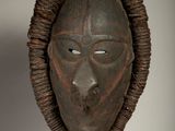 an african mask hanging on a wall in a room