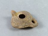 a small piece of pottery that has a hole in it