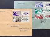 two envelopes with stamps on them sitting on a black surface