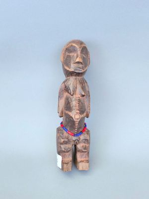 une petite statue en bois représentant un homme coiffé d'un chapeau