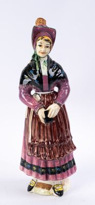 une figurine représentant une femme en robe et chapeau