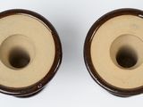 two brown vases sitting on top of a white table next to each other