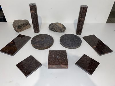 plusieurs morceaux de granit sont disposés en cercle sur une surface blanche