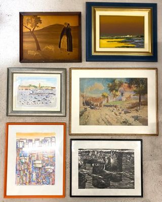 many framed pictures hanging on the wall of a room