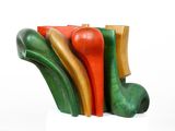 a wooden sculpture of different colors and shapes on a white surface