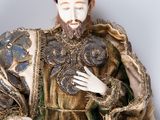 a figurine of a man with a beard sitting on a chair