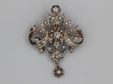 a silver brooch that is on a white surface