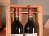 two bottles of wine sitting in a wooden box