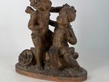 statue of a boy and a girl sitting on a rock with a dog