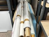 several rolls of paper are stacked on a shelf in a room