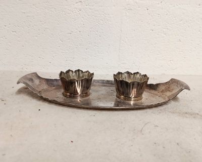 pair of silver plated candlesticks on a leaf shaped tray