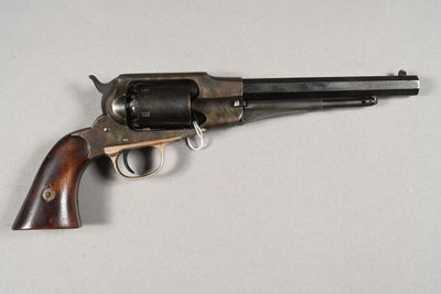 gros plan d'un pistolet sur une table à fond blanc