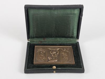 une plaque antique en bronze dans un cadre noir sur fond blanc