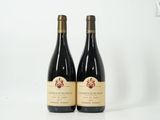 deux bouteilles de vin posées sur une table blanche