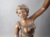 bronze statue of a woman holding a bird on a pedestal