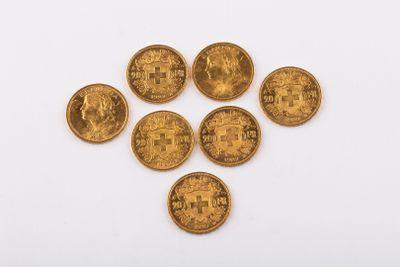 un groupe de cinq pièces d'or posées sur une surface blanche