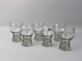 six verres de tailles différentes sont alignés sur une surface blanche