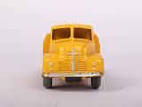 a yellow toy truck that is sitting on a white surface