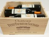 four bottles of wine in a wooden box
