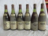six bouteilles de vin sont alignées sur une table