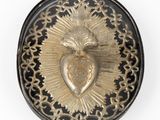 an image of a gold and black broochle with a heart on it