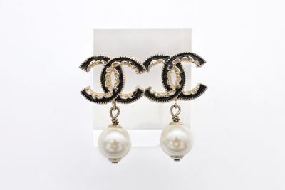 une paire de boucles d'oreilles pendantes ornées de perles et de perles noires et blanches