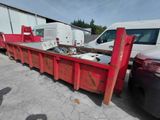 un camion-benne rouge garé à côté d'une camionnette blanche